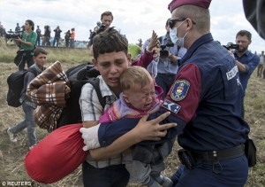 2C13F60500000578-3226888-A_Hungarian_policeman_attempts_to_stop_a_migrant_boy_carrying_a_-a-55_1441742675387