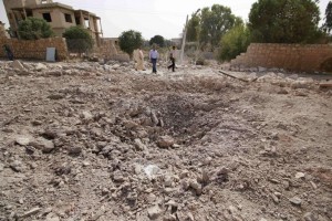 Men inspect a site hit by what activists said were air strikes carried out by the Russian air force on Reef al-Mohandeseen area in the western countryside of Aleppo, Syria