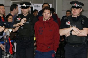 Barcelona's Lionel Messi is escorted by police officers as he arrives at Manchester Airport in Manchester, northern England
