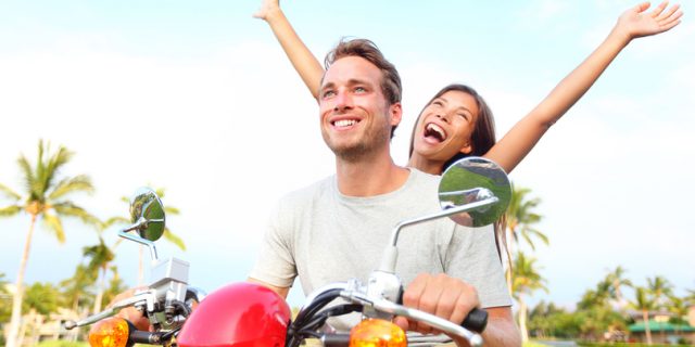 Happy free freedom couple driving scooter excited on summer holi
