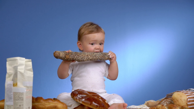 cute-baby-with-bread-on-blue-wall-eating-a-loaf_svz-hno2_thumbnail-full01